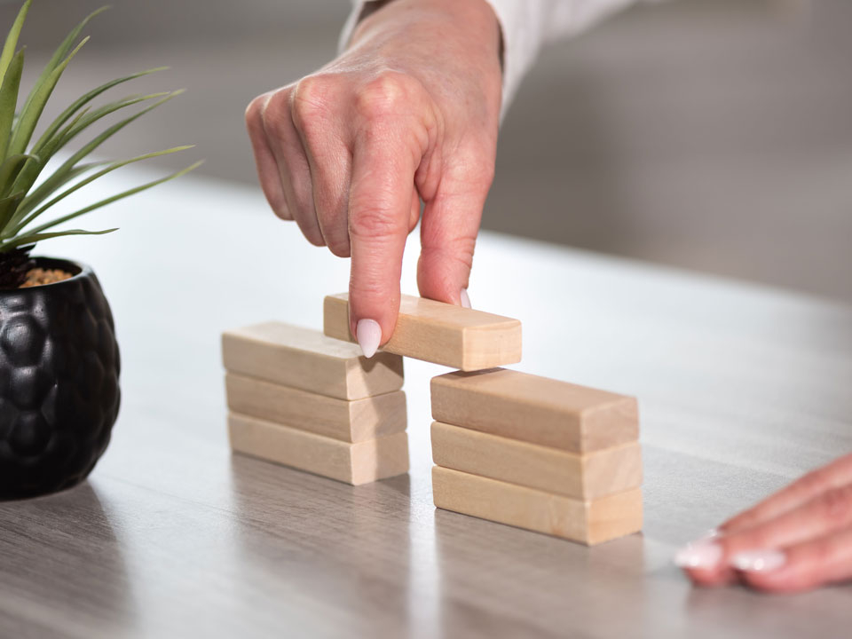 Hände bauen mit Holzbausteinen